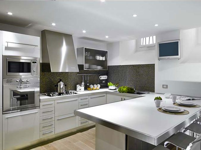 Kitchend with white cabinets and larg stainless steel oven hood